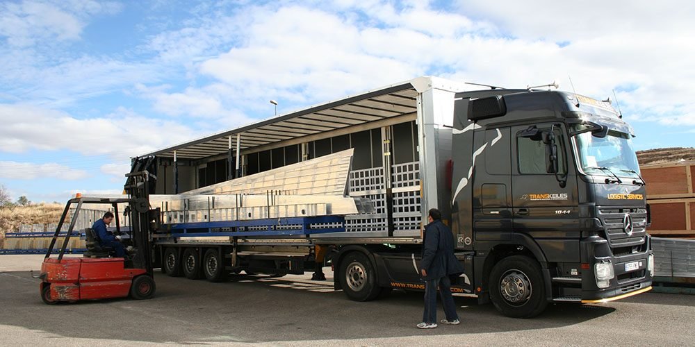 Carga lateral de un tráiler de Transkeiles con una carretilla elevadora, con la lona abierta