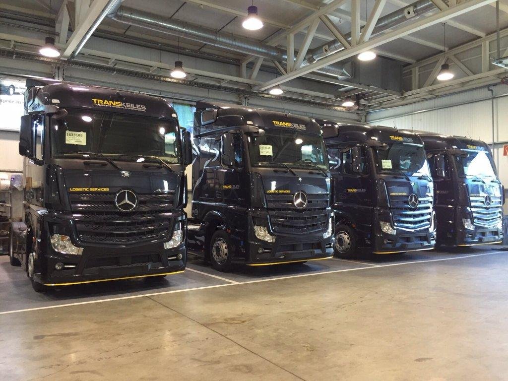 Tractoras negras de Transkeiles aparcadas en fila dentro de una nave